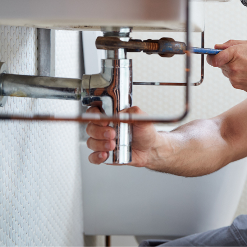 A close-up of a wrench tightening a pipe.