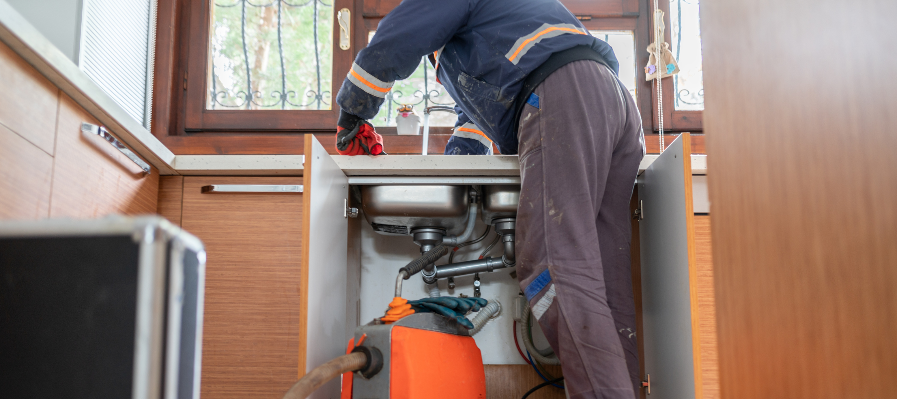 A plumber working on fixing a sink.